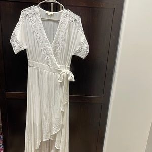 Never worn. Size Medium white high-low wrap dress with crochet details. Magnolia